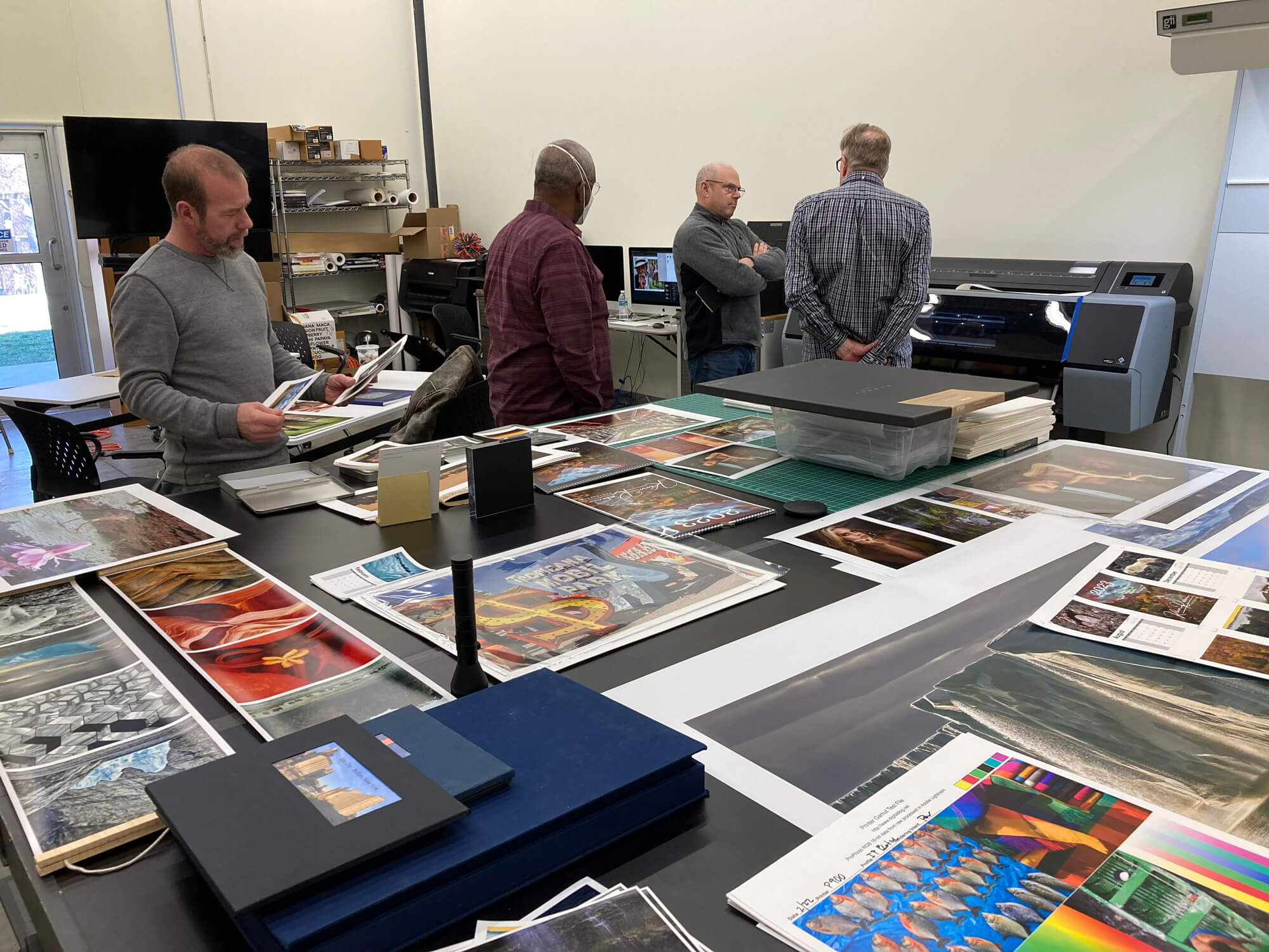 We have large inspection tables. Here we have a variety of print output that we can examine. Different paper surfaces, different ways to print projects
